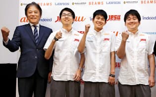 スポンサー企業のロゴ入りユニホームを着てポーズをとるアジア大会の日本代表選手（左は日本eスポーツ連合の岡村秀樹会長、8月9日）=共同