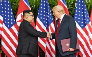 米朝首脳会談で共同声明に署名後、握手する北朝鮮の金正恩朝鮮労働党委員長(左)とトランプ米大統領(6月12日、シンガポール)=ロイター 米朝首脳会談で共同声明に署名後、握手する北朝鮮の金正恩朝鮮労働党委員長(左)とトランプ米大統領(6月12日、シンガポール)=ロイター