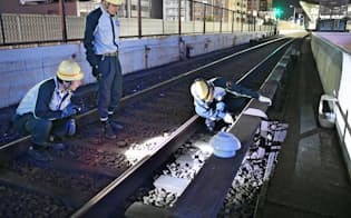 大阪メトロ御堂筋線の線路にある部品を交換する職員（8月31日、大阪市淀川区）