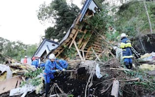土砂崩れで倒壊した家屋を捜索する消防団員ら（6日午後、北海道厚真町）