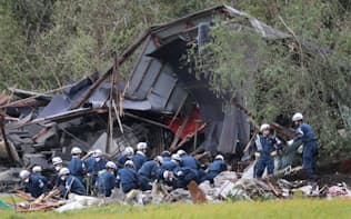 土砂崩れで倒壊した家屋で救助活動をする警察官ら（7日午前、北海道厚真町）