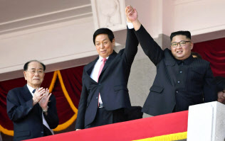 北朝鮮の建国70年を祝う軍事パレードで、中国の栗戦書・全人代常務委員長(中央)と手を上げて歓声に応える金正恩朝鮮労働党委員長。左は金永南最高人民会議常任委員長=9日、平壌の金日成広場(共同) 北朝鮮の建国70年を祝う軍事パレードで、中国の栗戦書・全人代常務委員長(中央)と手を上げて歓声に応える金正恩朝鮮労働党委員長。左は金永南最高人民会議常任委員長=9日、平壌の金日成広場(共同)