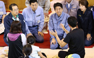北海道厚真町の避難所で被災者(手前)の話を聞く安倍首相(中央右)ら(9日午後)=代表撮影・共同 北海道厚真町の避難所で被災者(手前)の話を聞く安倍首相(中央右)ら(9日午後)=代表撮影・共同
