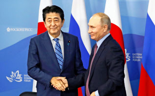 中国のネットでは安倍首相の外交を絶賛するコメントが多数みられる(10日、ウラジオストクでロシアのプーチン大統領と握手する安倍首相)=共同 中国のネットでは安倍首相の外交を絶賛するコメントが多数みられる(10日、ウラジオストクでロシアのプーチン大統領と握手する安倍首相)=共同