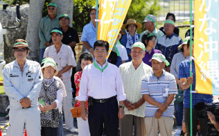 沖縄県知事選が告示され、候補者の第一声を聞く支持者ら(13日午前、沖縄県・伊江島)=共同 沖縄県知事選が告示され、候補者の第一声を聞く支持者ら(13日午前、沖縄県・伊江島)=共同