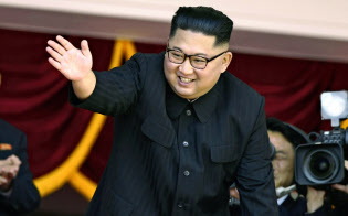9日、平壌の金日成広場で、北朝鮮の建国70年を祝う軍事パレードを観覧し歓声にこたえる金正恩委員長=共同 9日、平壌の金日成広場で、北朝鮮の建国70年を祝う軍事パレードを観覧し歓声にこたえる金正恩委員長=共同