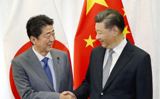 会談で握手する中国の習近平国家主席(右)と安倍首相(12日、ロシア・ウラジオストク)=共同 会談で握手する中国の習近平国家主席(右)と安倍首相(12日、ロシア・ウラジオストク)=共同