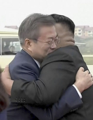 平壌入りし、金委員長と抱き合う韓国の文大統領(18日午前)=平壌映像共同取材団・AP 平壌入りし、金委員長と抱き合う韓国の文大統領(18日午前)=平壌映像共同取材団・AP