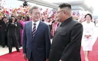 平壌の空港で、出迎えた北朝鮮の金正恩委員長（手前右）と並んで歩く韓国の文在寅大統領（同左）=18日、平壌写真共同取材団撮影