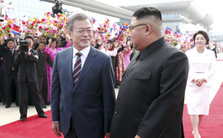 平壌の空港で、出迎えた北朝鮮の金正恩委員長(手前右)と並んで歩く韓国の文在寅大統領(同左)=18日、平壌写真共同取材団撮影 平壌の空港で、出迎えた北朝鮮の金正恩委員長(手前右)と並んで歩く韓国の文在寅大統領(同左)=18日、平壌写真共同取材団撮影
