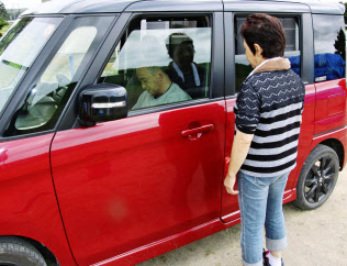 自宅を片付ける間、体が不自由な夫(左)を車の中で待たせる女性(16日、北海道厚真町)=共同 自宅を片付ける間、体が不自由な夫(左)を車の中で待たせる女性(16日、北海道厚真町)=共同