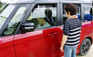 自宅を片付ける間、体が不自由な夫(左)を車の中で待たせる女性(16日、北海道厚真町)=共同 自宅を片付ける間、体が不自由な夫(左)を車の中で待たせる女性(16日、北海道厚真町)=共同