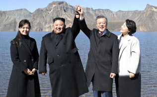 朝鮮半島最高峰の白頭山を訪問し、カルデラ湖「天池」でつないだ手を上げる北朝鮮の金正恩朝鮮労働党委員長(中央左)と韓国の文在寅大統領(同右)。夫人が同行した(20日)=平壌写真共同取材団撮影 朝鮮半島最高峰の白頭山を訪問し、カルデラ湖「天池」でつないだ手を上げる北朝鮮の金正恩朝鮮労働党委員長(中央左)と韓国の文在寅大統領(同右)。夫人が同行した(20日)=平壌写真共同取材団撮影