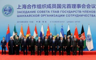 6月、中国・青島で開いた上海協力機構首脳会議に出席したイランのロウハニ大統領(最前列の左から2人目)=ロイター 6月、中国・青島で開いた上海協力機構首脳会議に出席したイランのロウハニ大統領(最前列の左から2人目)=ロイター