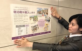 アーキエムズ（京都市）の運営するホテルではフロント近くのポスターで宿泊税の導入を告知する