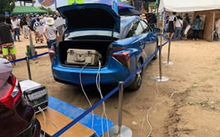九大は燃料電池車を使い携帯電話の充電サービスなどを行う実証試験を実施した（福岡県糸島市で開催された野外フェス）