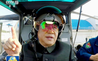 中国中央テレビが29日放映した、遼寧省の軍部隊でヘルメットをかぶり武装ヘリコプターの操縦席に着く習近平国家主席の映像=共同 中国中央テレビが29日放映した、遼寧省の軍部隊でヘルメットをかぶり武装ヘリコプターの操縦席に着く習近平国家主席の映像=共同