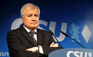15日、記者会見で腕組みするキリスト教社会同盟(CSU)党首のゼーホーファー内相=AP 15日、記者会見で腕組みするキリスト教社会同盟(CSU)党首のゼーホーファー内相=AP