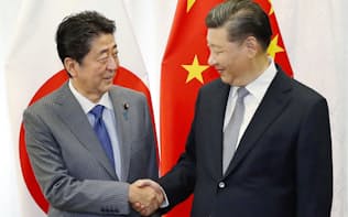 握手する中国の習近平（シー・ジンピン）国家主席（右）と安倍首相（9月12日、ロシア・ウラジオストク）=共同