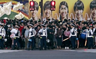 東京・渋谷駅前のスクランブル交差点で警備にあたる警察官たち（28日夕）=共同