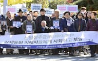 30日、判決が言い渡される前に韓国最高裁前で集会を開く原告側の支援者ら=共同