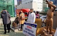 韓国政府は募集、官あっせん、徴用を分けずに「強制徴用被害者」と表現する（2017年12月、釜山に臨時で展示された徴用工像の模型）