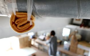 天井をつたう排気管からの雨漏りを防ぐためタオルを結びつけるマンションの居室（10月、東京都新宿区）