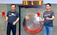 9月28日、香港取引所上場の記念式典でドラを鳴らす衆安在線財産保険の歐亜平会長(左)