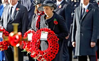 11日、ロンドンでの戦没者追悼式で花輪をささげるメイ英首相=ロイター