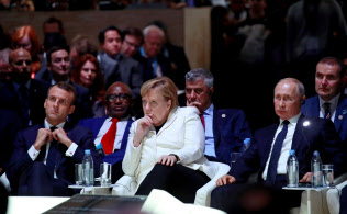 11日、パリ平和フォーラムに出席した(手前左から)マクロン氏、メルケル氏、プーチン氏=ロイター 11日、パリ平和フォーラムに出席した(手前左から)マクロン氏、メルケル氏、プーチン氏=ロイター