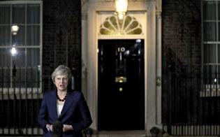 14日夜、英首相官邸前で声明を読み上げるメイ首相=AP 14日夜、英首相官邸前で声明を読み上げるメイ首相=AP