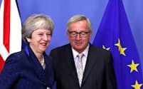 メイ英首相(左)を迎えるユンケル欧州委員長（24日、ブリュッセルのEU本部）=ロイター