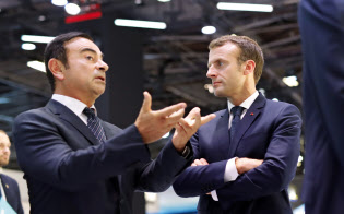 10月3日、パリモータショーでマクロン仏大統領と話すカルロス・ゴーン元日産会長=AP 10月3日、パリモータショーでマクロン仏大統領と話すカルロス・ゴーン元日産会長=AP