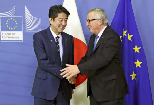 ユンケル欧州委員長(右)と握手する安倍首相(18日、ブリュッセル)=代表撮影・共同 ユンケル欧州委員長(右)と握手する安倍首相(18日、ブリュッセル)=代表撮影・共同