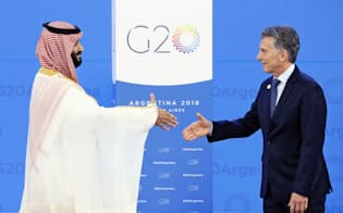 30日、G20を前にアルゼンチンのマクリ大統領（右）の出迎えを受けるサウジアラビアのムハンマド皇太子（ブエノスアイレス）=共同