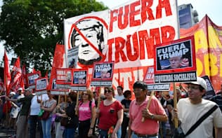 「トランプは出て行け」と書かれた旗などを掲げG20首脳会議に反対する市民ら（30日、ブエノスアイレス）