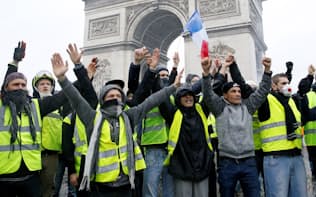 シンボルである「黄色いベスト」を着用しパリの凱旋門前に陣取るデモ参加者ら（1日）=ロイター