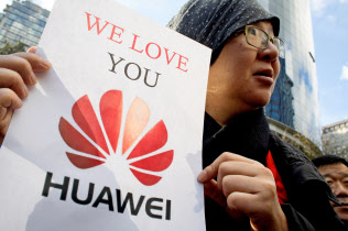 裁判所の前でファーウェイへの支持を訴える中国人旅行者(10日、バンクーバー)=ロイター 裁判所の前でファーウェイへの支持を訴える中国人旅行者(10日、バンクーバー)=ロイター