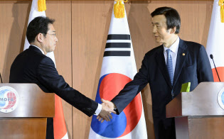 共同記者発表を終え握手する当時の岸田外相(左)と韓国の尹炳世外相(2015年12月28日、ソウルの韓国外務省)=共同 共同記者発表を終え握手する当時の岸田外相(左)と韓国の尹炳世外相(2015年12月28日、ソウルの韓国外務省)=共同