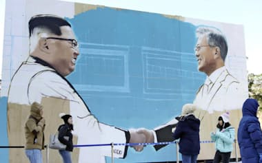 韓国大統領府前にある広場で作成中の文在寅大統領と北朝鮮の金正恩委員長が握手する絵（8日、ソウル）=共同