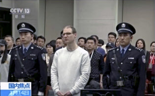 麻薬密輸罪に問われた大連地裁での差し戻し審で、死刑判決を言い渡されたカナダ人のロバート・ロイド・シェレンバーグ被告(中央。中国中央テレビから)=AP 麻薬密輸罪に問われた大連地裁での差し戻し審で、死刑判決を言い渡されたカナダ人のロバート・ロイド・シェレンバーグ被告(中央。中国中央テレビから)=AP