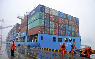 中国の2018年12月の輸出額は追加関税の影響で米国との貿易が低迷し、前年同月の水準を下回った(中国・青島の港に停泊するコンテナ船)=AP 中国の2018年12月の輸出額は追加関税の影響で米国との貿易が低迷し、前年同月の水準を下回った(中国・青島の港に停泊するコンテナ船)=AP