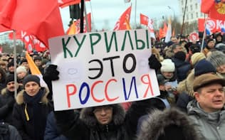 20日、モスクワで開かれた集会で「クリール諸島（北方領土）はロシア領土だ」と書かれた紙を掲げる参加者ら