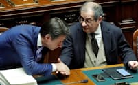 12月29日、イタリア下院で19年度予算が可決、成立し握手するコンテ首相(左)とトリア経済・財務相=ロイター