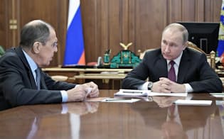 2日、ラブロフ外相(左)と協議するプーチン大統領（モスクワの大統領府）=ロイター