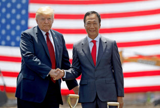 パネル工場の起工式で握手する鴻海の郭氏(右)とトランプ氏(6月、米中西部ウィスコンシン州)=ロイター パネル工場の起工式で握手する鴻海の郭氏(右)とトランプ氏(6月、米中西部ウィスコンシン州)=ロイター