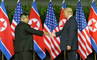 初の首脳会談で握手を交わす北朝鮮の金正恩委員長(左)とトランプ米大統領(2018年6月12日、シンガポール)=AP 初の首脳会談で握手を交わす北朝鮮の金正恩委員長(左)とトランプ米大統領(2018年6月12日、シンガポール)=AP