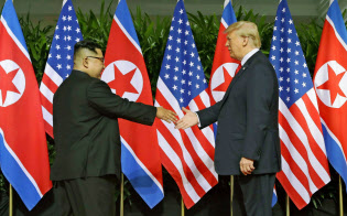初の首脳会談で握手を交わす北朝鮮の金正恩委員長(左)とトランプ米大統領=2018年6月12日、シンガポール(AP) 初の首脳会談で握手を交わす北朝鮮の金正恩委員長(左)とトランプ米大統領=2018年6月12日、シンガポール(AP)