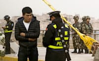 新疆ウイグル自治区のカシュガルで住民のIDカードをチェックする警察官=ロイター