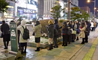 札幌市中心部でタクシー乗り場に列を作る人たち(21日午後10時24分)=共同 札幌市中心部でタクシー乗り場に列を作る人たち(21日午後10時24分)=共同